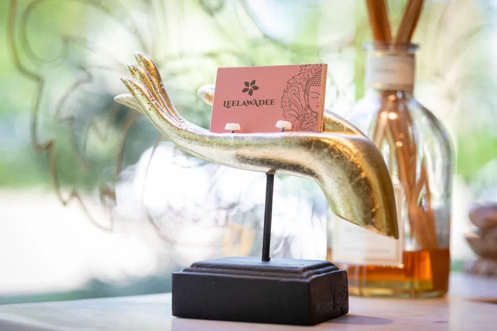 Gouden hand die het roze visitekaartje van Leelawadee vasthoudt